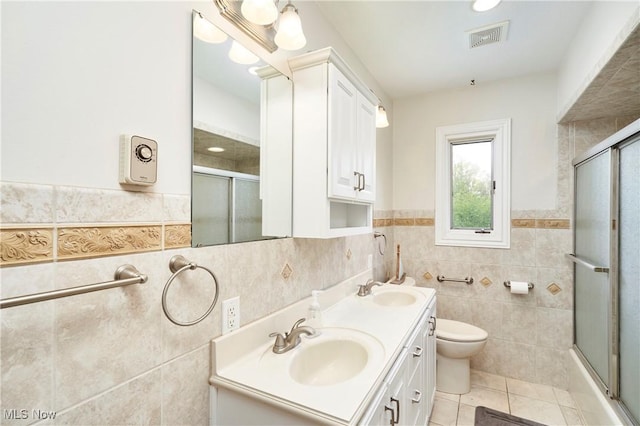 2530 Holgate Rd, Akron, OH 44313 - bathroom featuring tile walls, tile patterned flooring, double vanity, toilet, and a wainscoted wall