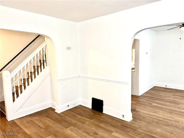 3631 E 104th St, Cleveland, OH 44105 - spare room with arched walkways, wood finished floors, stairway, ceiling fan, and baseboards