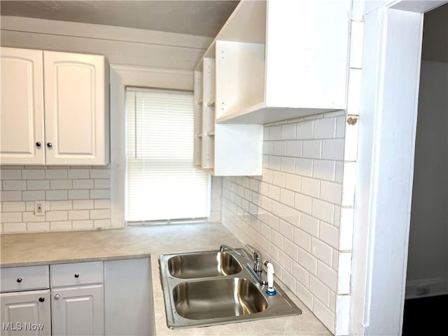 3631 E 104th St, Cleveland, OH 44105 - kitchen featuring a sink, backsplash, white cabinetry, and light countertops