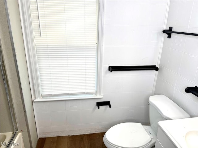 3631 E 104th St, Cleveland, OH 44105 - full bathroom with wood finished floors, tile walls, toilet, a bath, and vanity