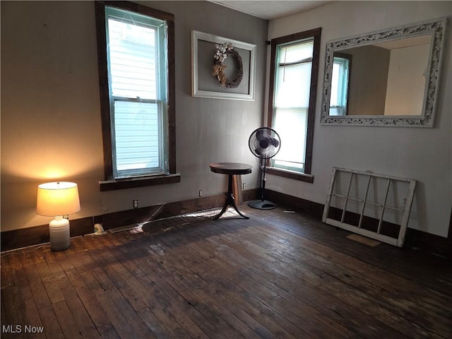 spare room featuring healthy amount of natural light, hardwood / wood-style floors, and baseboards