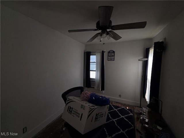 bedroom featuring baseboards, a ceiling fan, and dark wood-style flooring