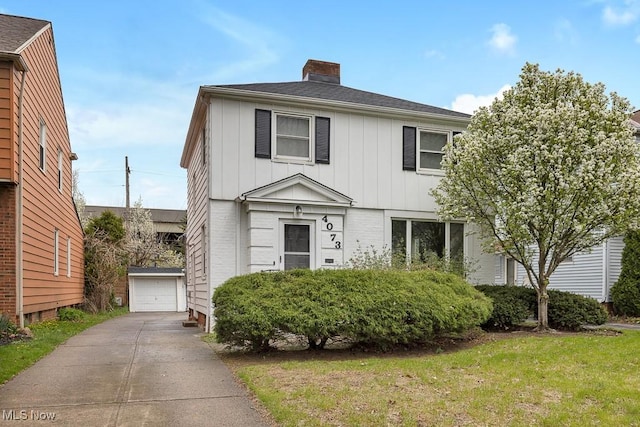 4073 Bushnell Rd, University Heights, OH 44118 - view of front of property featuring board and batten siding, a chimney, an outdoor structure, and a front lawn