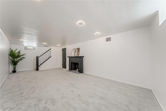 4073 Bushnell Rd, University Heights, OH 44118 - unfurnished living room featuring light carpet, a fireplace with flush hearth, and stairs