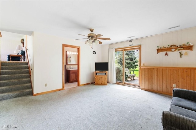 16139 E Main St, Mount Eaton, OH 44659 - carpeted living area with baseboards, a ceiling fan, stairs, and wood walls