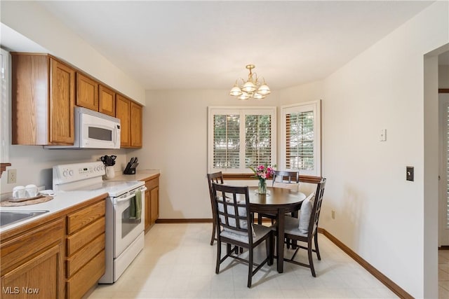 489 Paul Tell Trl, Tallmadge, OH 44278 - kitchen featuring white appliances, a chandelier, brown cabinets, light countertops, and pendant lighting