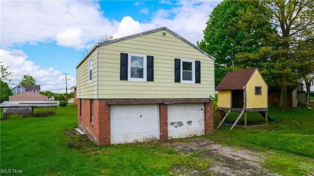 rear view of property featuring a yard and driveway