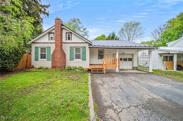 3509 Fargo Dr, Ashtabula, OH 44004 - view of front of property with an attached garage, a chimney, metal roof, driveway, and covered porch