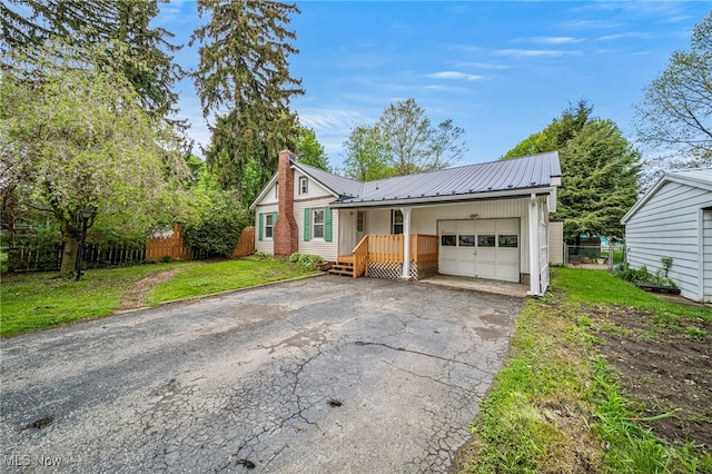 3509 Fargo Dr, Ashtabula, OH 44004 - view of front of property with a garage, driveway, a chimney, metal roof, and board and batten siding