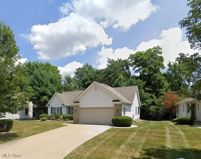 1250 Spring Ridge Cir, Alliance, OH 44601 - view of front of home featuring an attached garage, brick siding, concrete driveway, and a front yard