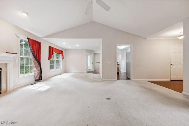 1250 Spring Ridge Cir, Alliance, OH 44601 - unfurnished living room featuring lofted ceiling, carpet floors, baseboards, a tile fireplace, and a ceiling fan