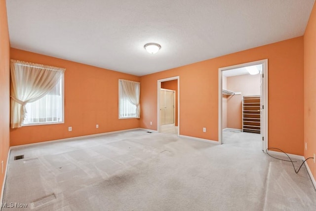 1250 Spring Ridge Cir, Alliance, OH 44601 - unfurnished bedroom with baseboards, a spacious closet, carpet, a closet, and a textured ceiling