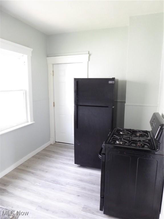 2067 W 105th St, Cleveland, OH 44102 - kitchen featuring black appliances, light wood-style flooring, and baseboards