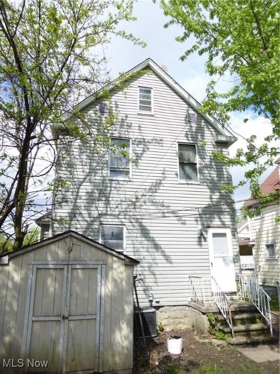 2067 W 105th St, Cleveland, OH 44102 - back of house featuring a storage unit, an outbuilding, and central air condition unit