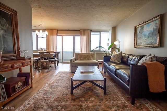 12900 Lake Ave Unit 1915, Lakewood, OH 44107 - living room featuring a chandelier, wood finished floors, and a textured ceiling