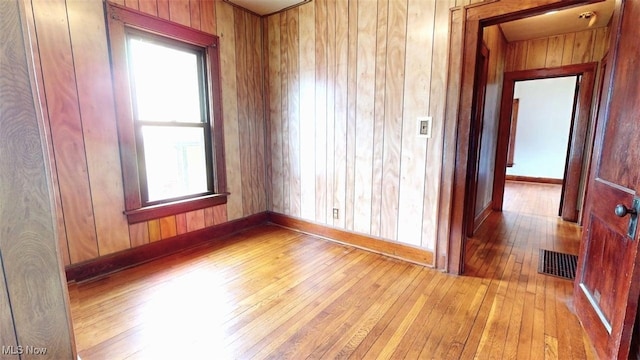 1632 Lawrence St, Parkersburg, WV 26101 - unfurnished room with light wood-type flooring, baseboards, plenty of natural light, and wooden walls
