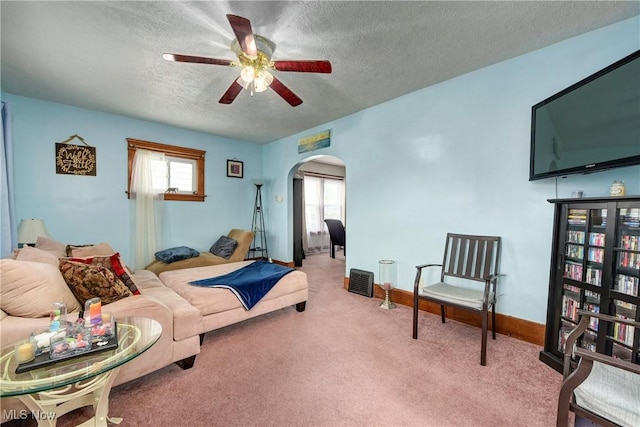 bedroom featuring arched walkways, a textured ceiling, carpet, multiple windows, and baseboards