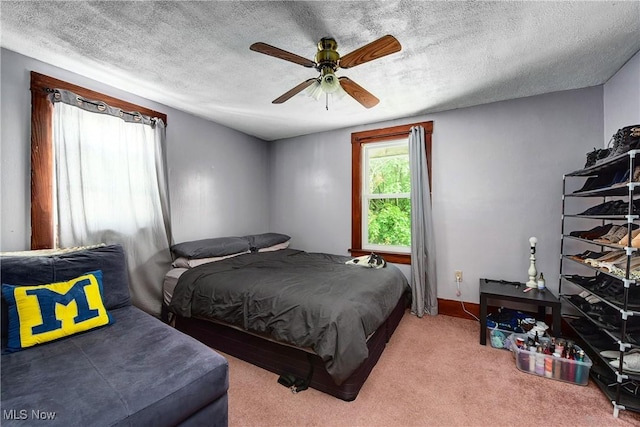 carpeted bedroom featuring a textured ceiling and ceiling fan
