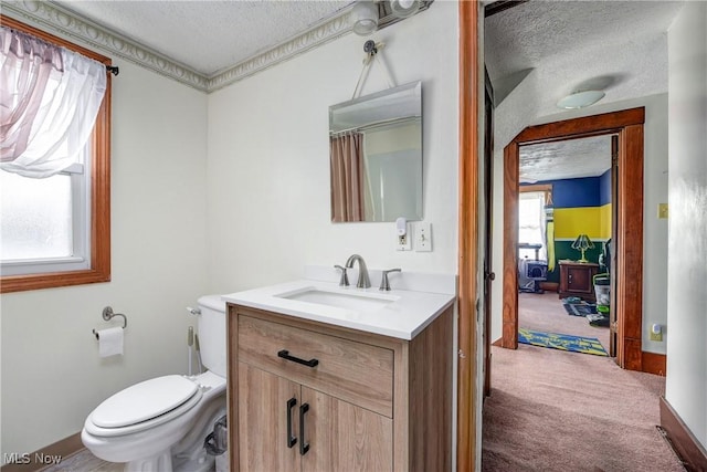 bathroom with a textured ceiling, vanity, toilet, and baseboards