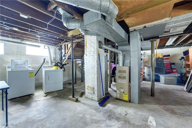 below grade area featuring washing machine and clothes dryer and heating unit