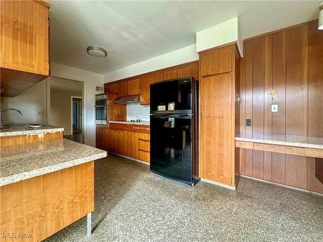 1357 Kearney St, Niles, OH 44446 - kitchen featuring a sink, brown cabinets, freestanding refrigerator, stainless steel oven, and under cabinet range hood