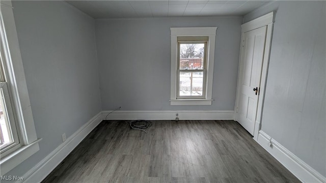 empty room featuring wood finished floors and baseboards