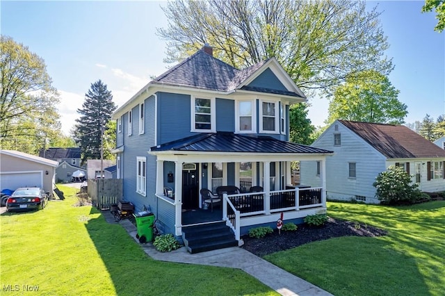 view of front of property featuring covered porch, a standing seam roof, a front lawn, metal roof, and a chimney