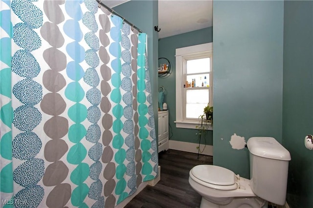 bathroom featuring wood finished floors, toilet, baseboards, and a shower with curtain