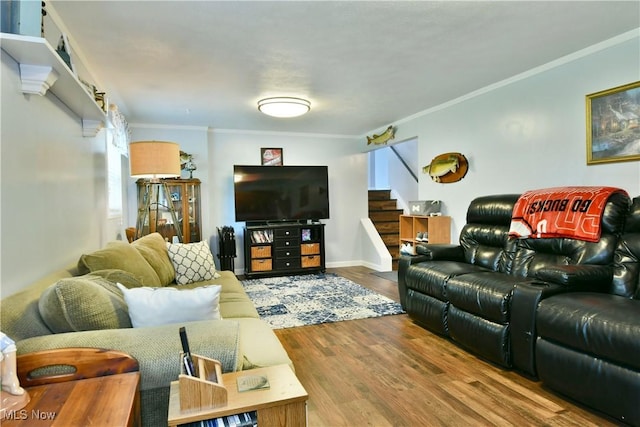 living room with stairs, crown molding, wood finished floors, and plenty of natural light