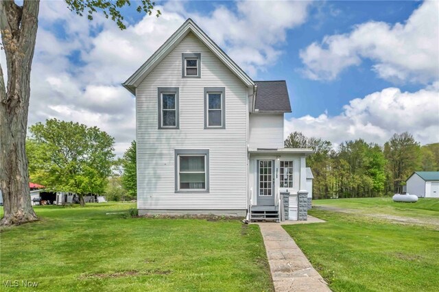rear view of house with a lawn and entry steps