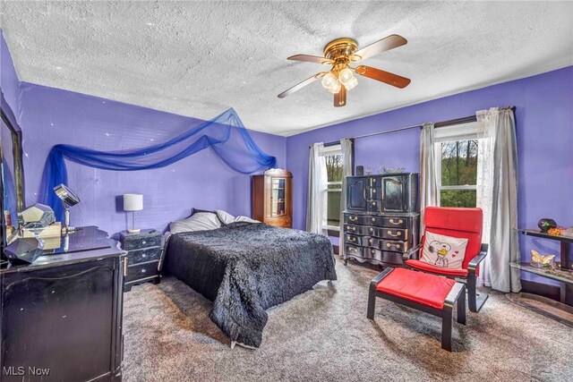 carpeted bedroom with a textured ceiling and a ceiling fan