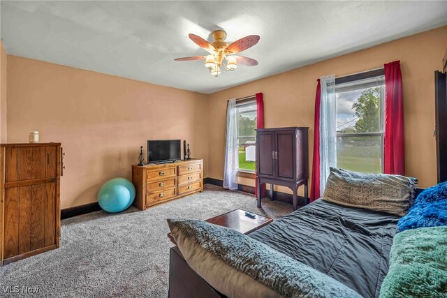 carpeted bedroom with baseboards and a ceiling fan