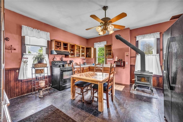 dining room with a wood stove and a ceiling fan
