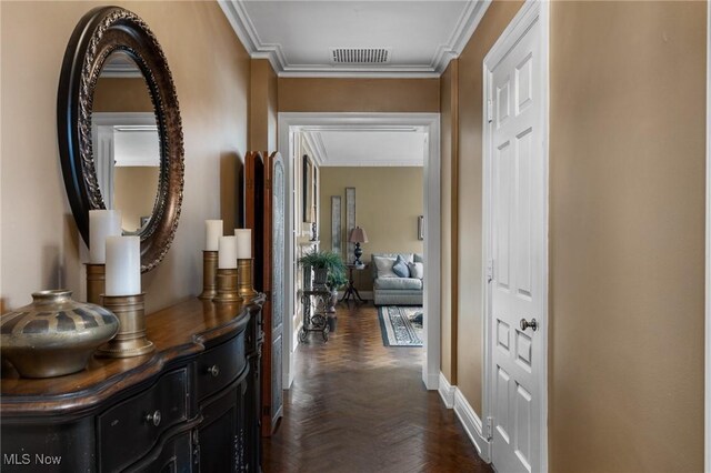 corridor featuring attic access, crown molding, and baseboards