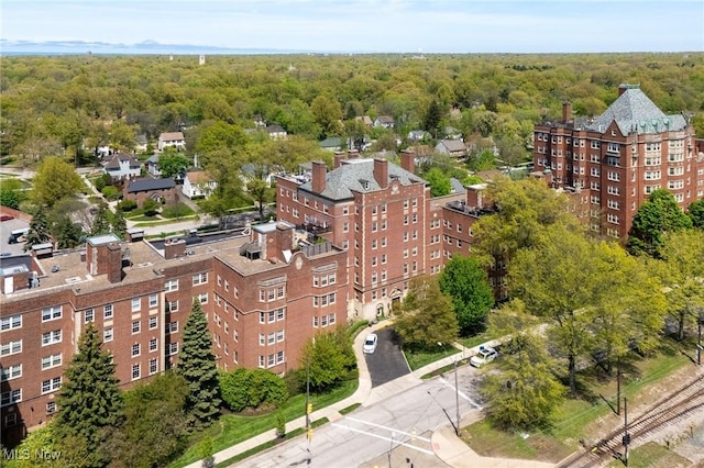 drone / aerial view of a heavily wooded area and apartment complex