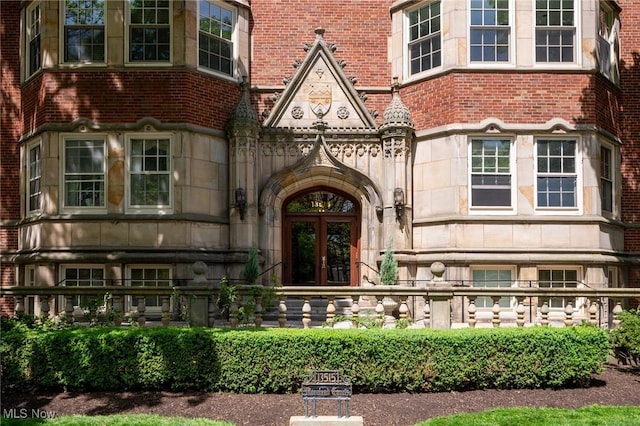 property entrance featuring stone siding, french doors, and brick siding