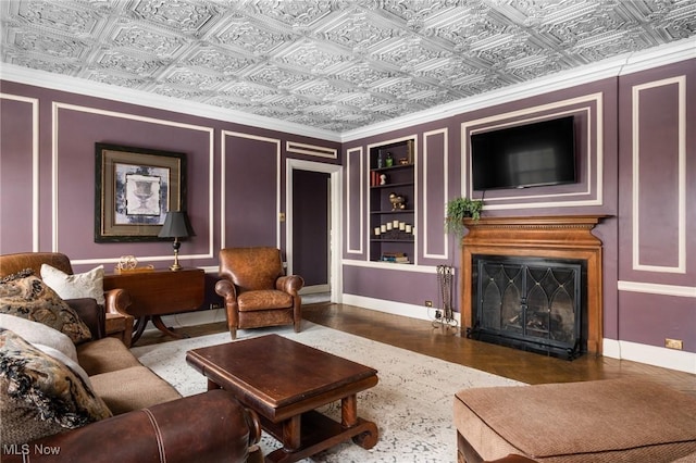 living area featuring built in features, baseboards, a fireplace, and an ornate ceiling