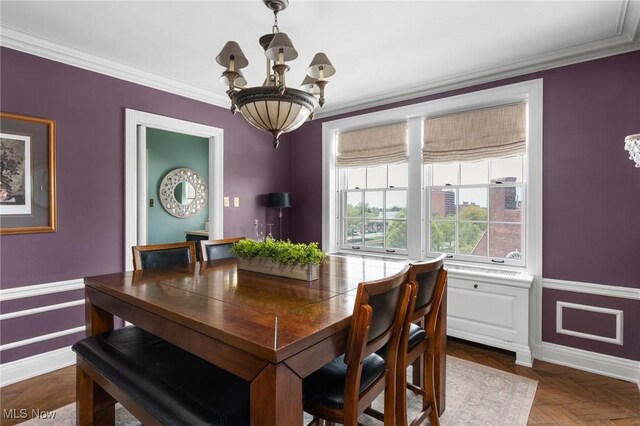 dining room with a chandelier and crown molding