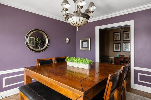 dining area featuring a chandelier, baseboards, and ornamental molding