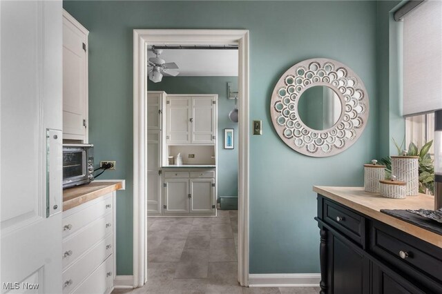 bathroom with baseboards, ceiling fan, and vanity