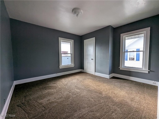 spare room with carpet and baseboards