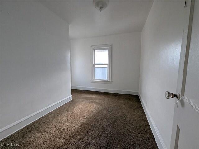 carpeted empty room featuring baseboards