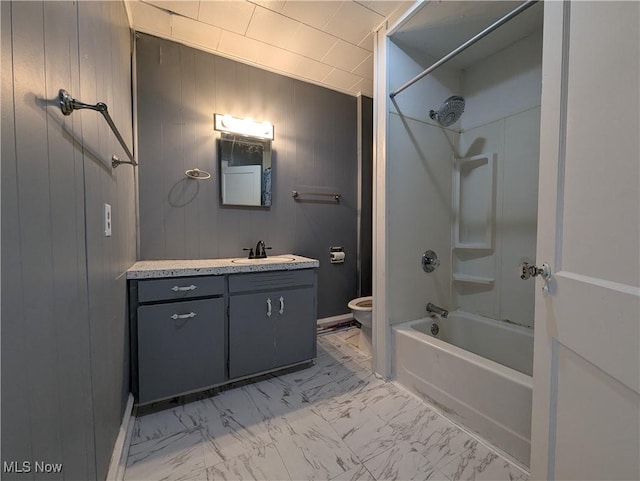 full bath with marble finish floors, toilet, vanity,  shower combination, and wood walls