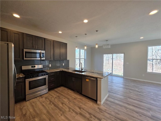 990 E Blvd, Aurora, OH 44202 - kitchen with appliances with stainless steel finishes, a sink, light wood-type flooring, light stone counters, and baseboards