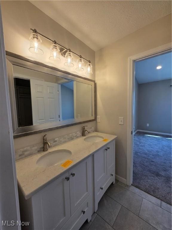 990 E Blvd, Aurora, OH 44202 - bathroom with double vanity, a textured ceiling, tile patterned flooring, and baseboards