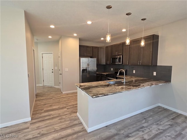 990 E Blvd, Aurora, OH 44202 - kitchen with stainless steel appliances, dark stone countertops, baseboards, a peninsula, and recessed lighting