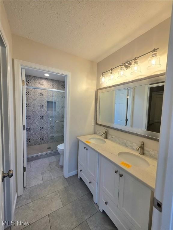 990 E Blvd, Aurora, OH 44202 - full bathroom featuring double vanity, a shower stall, toilet, tile patterned flooring, and a textured ceiling