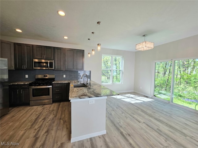 990 E Blvd, Aurora, OH 44202 - kitchen featuring appliances with stainless steel finishes, a sink, a peninsula, baseboards, and decorative backsplash