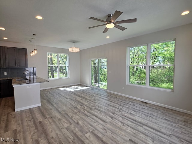 990 E Blvd, Aurora, OH 44202 - unfurnished living room featuring baseboards, wood finished floors, ceiling fan, recessed lighting, and a chandelier