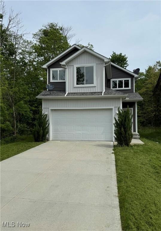 990 E Blvd, Aurora, OH 44202 - view of front of home featuring a garage, board and batten siding, driveway, and a front yard